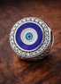 Blue Evil Eye Medallion - Blue Evil Eye Medallion Charm — display on walnut