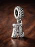 16th Celebration Charm — display on walnut
