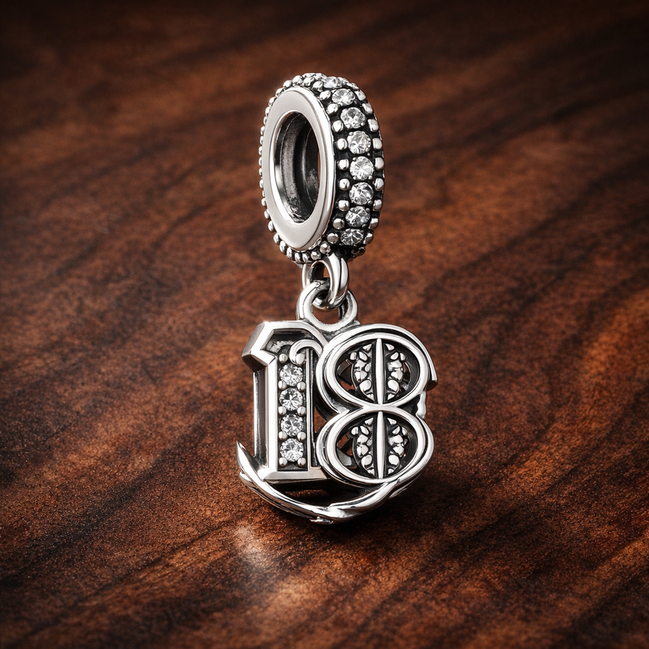 18th Celebration Dangle Charm — display on walnut