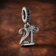 21st Celebration Dangle Charm — display on walnut