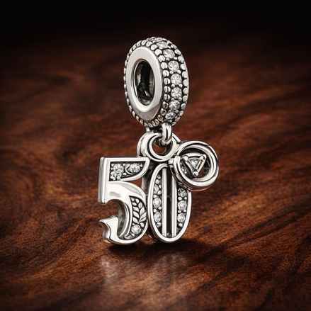 50th Celebration Dangle Charm — display on walnut