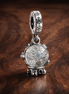Snowflake Snow Globe Dangle Charm — display on walnut