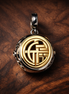 Two-tone Fú Spinning Dangle Charm — display on walnut