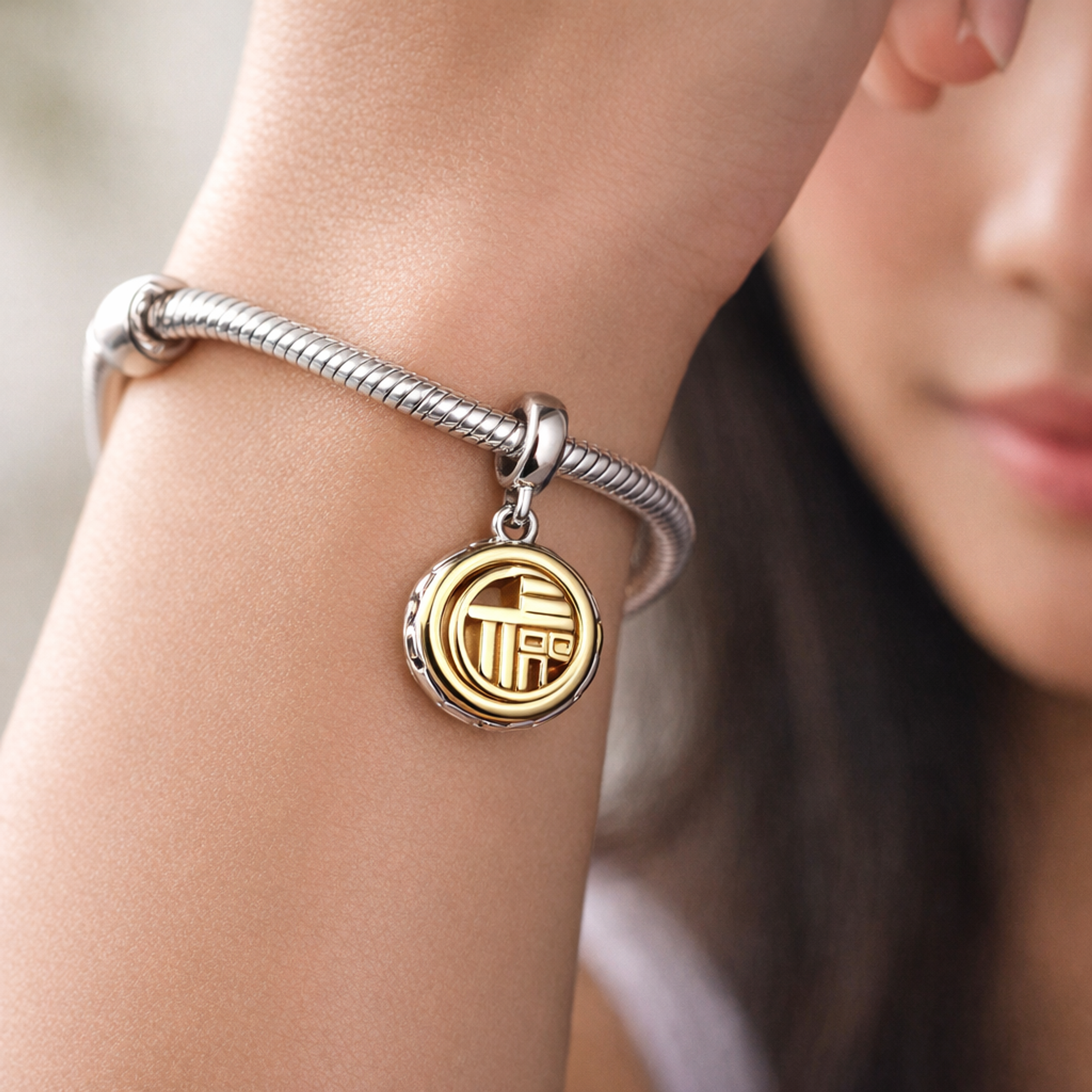 Two-tone Fú Spinning Dangle Charm — worn on wrist